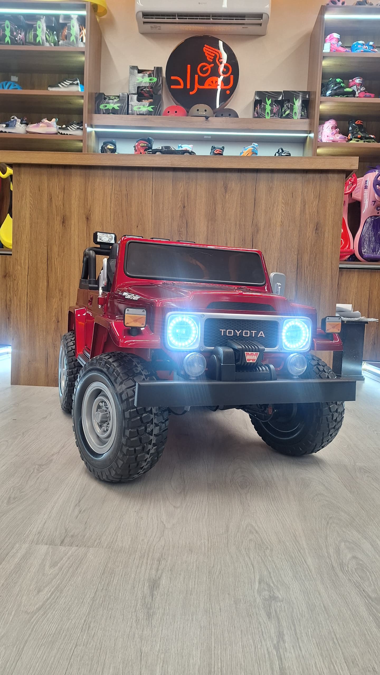 ماشین شارژی کودک مدل تویوتا لندکروز افرودی چهارموتوره لاستیک اسفنجی متالیک قرمز